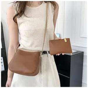 Détail d'un ensemble de sacs en cuir marron grainé avec sacoche et pochette zippée