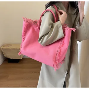 Détail du grand sac cabas en toile rose fuchsia avec franges et doubles poignées