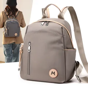 Mochila de tela Oxford impermeable para mujer en color topo con bolsillo frontal de cremallera