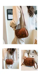Detail of a brown vintage saddle bag with matte PU leather and gold metal buckles