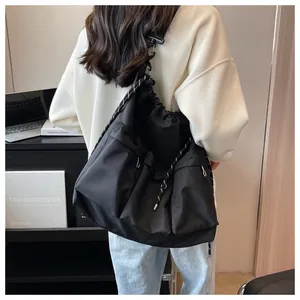 Detail of black nylon crossbody bag with multi-pocket design and adjustable rope strap
