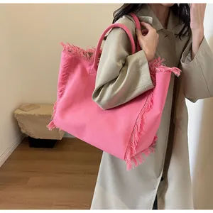 Détail du grand sac cabas en toile rose avec bords à franges et design élégant
