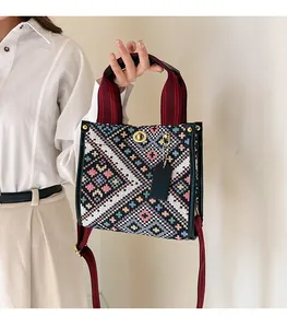 Detailed shot of ethnic pattern tote bag with woven straps and gold twist-lock closure