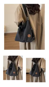 Close-up of black canvas tote bag showing versatile shoulder and backpack straps functionality