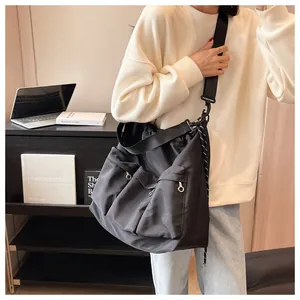 Detail of black nylon tote bag with silver ring zippers and wide shoulder strap