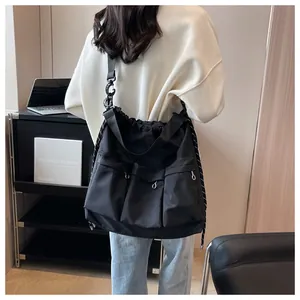 Detail showing the large capacity and multiple pockets of this black crossbody nylon bag