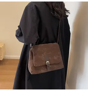 Brown vintage postman bag shown on model in a minimalist home setting back view