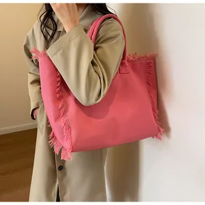 Détail du cabas en toile rose montrant les bords effilochés et le matériau texturé