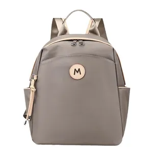 Lightweight khaki nylon backpack with large capacity and letter M patch for travel
