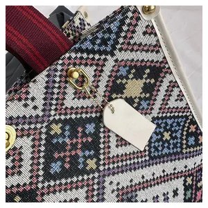 Close-up of ethnic woven tote bag with colorful geometric patterns and gold metal hardware