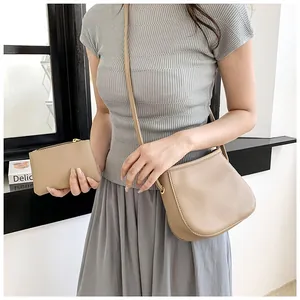 Détail de l'ensemble sac seau beige avec pochette assortie et fermetures éclair dorées