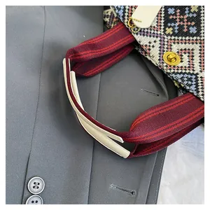 Detailed view of bohemian woven tote bag with geometric patterns and metallic turn-lock