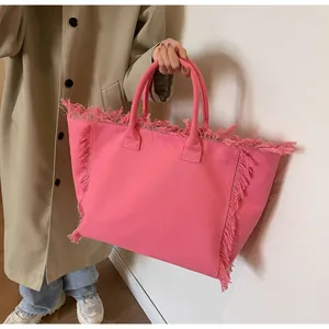 Mannequin portant un grand cabas rose en toile avec franges et poignées rondes