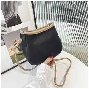Sac seau bicolore noir et beige en forme de selle avec bandoulière fine élégante