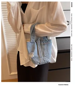 Λεπτομέρεια από γαλάζια τσάντα denim bucket με ξεφτισμένες άκρες και ιδιαίτερη υφή