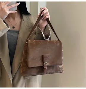 Detailed view of vintage brown crossbody bag with distressed leather and metal buckle