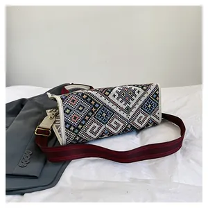Detail of ethnic geometric woven pattern and wide striped strap on canvas tote bag