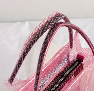 Détail de la poignée en PVC rose avec texture filet noir et fermeture éclair