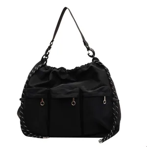 Large black nylon drawstring tote bag with multi-pocket design and woven rope detail