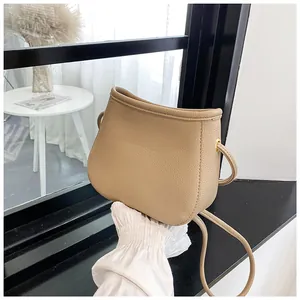 Sac seau beige chic pour femmes en cuir grainé avec bandoulière au design minimaliste moderne