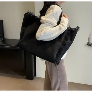 Gros plan détaillé du grand sac cabas en toile avec bordures à franges noires chic