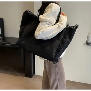Détails d'un grand sac fourre-tout en toile noire avec des bords à franges élégants