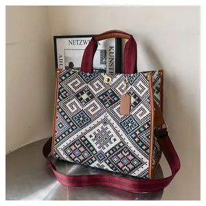 Detail of bohemian canvas tote with ethnic geometric patterns and brown leather handles