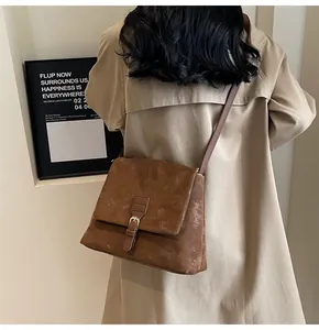 Back view of a vintage brown messenger bag with flap and decorative buckle detail