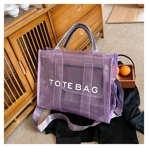 Detail of purple mesh tote bag with white TOTE BAG text and adjustable shoulder strap