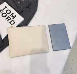 Vista detallada de un bolso de lino crema con cremallera comparado con una tableta