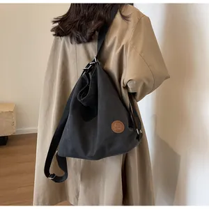 Black canvas tote bag styled with a beige trench coat for a minimalist daily outfit