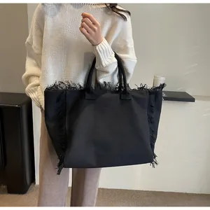 Gros plan détaillé d'un sac cabas en toile noire avec des bords à franges stylés