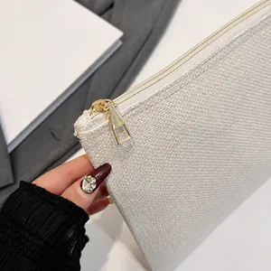 Primer plano detallado de la cremallera de metal dorado en bolso de lona texturizada