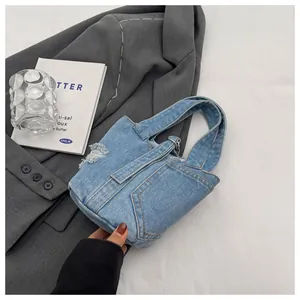 Λεπτομέρεια γαλάζιας τσάντας denim με σκισμένες τσέπες και θηλιές για ζώνη