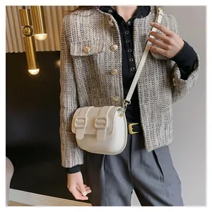 Chic beige crossbody square bag with twin straps shown on model in a tweed jacket