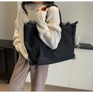 Détails du grand sac cabas en toile noire avec finitions effilochées et longues anses