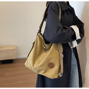 Detail view of khaki large capacity canvas tote with leather logo patch and strap