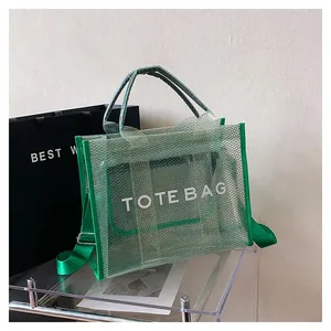 Detail of green mesh tote bag with white text, matching inner pouch and shoulder strap