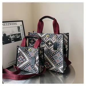 Detailed macro of two woven tote bags in geometric patterns with stylish metal buckle lock
