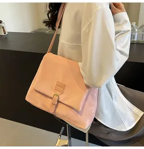 Detail of pink matte messenger bag with golden buckle and sleek flap design