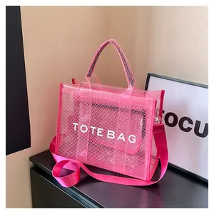 Detailed view of pink mesh tote bag with TOTE BAG lettering and long shoulder strap