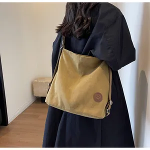 Detail view of ginger yellow large tote bag on model showing soft texture and strap