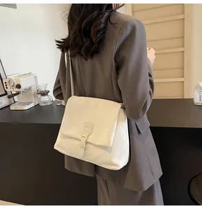 Creamy white vintage messenger bag shown in a lifestyle setting with soft leather texture