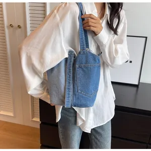 Close-up of denim bucket bag showing patchwork pockets and belt loop details