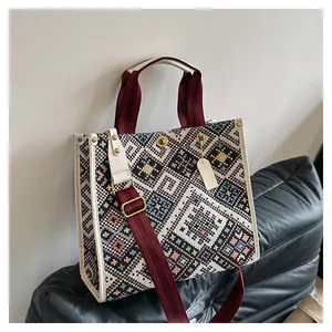 Detail of ethnic geometric woven pattern and metallic twist lock on canvas tote bag