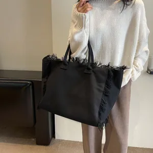 Grand sac cabas en toile noire avec bordures à franges et poignée design élégante
