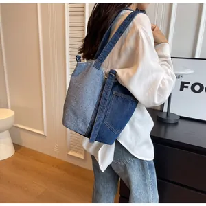 Detail of color-block denim tote bag with deep blue stitching and side pocket