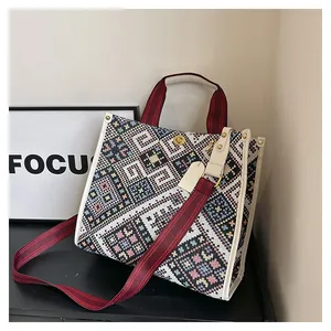 Detailed close-up of Bohemian woven tote bag with colorful geometric patterns and gold buckle