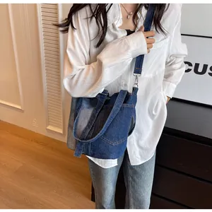 Detail of blue denim patchwork bucket bag with silver hardware and adjustable strap
