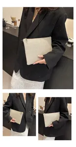 Détail d'une pochette tissée beige chic avec fermeture éclair dorée et fibre synthétique